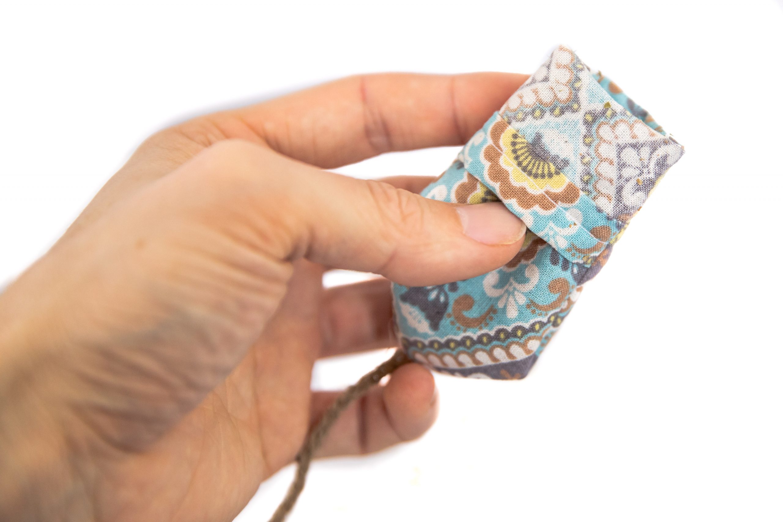 A hand holding a fabric mouse toy