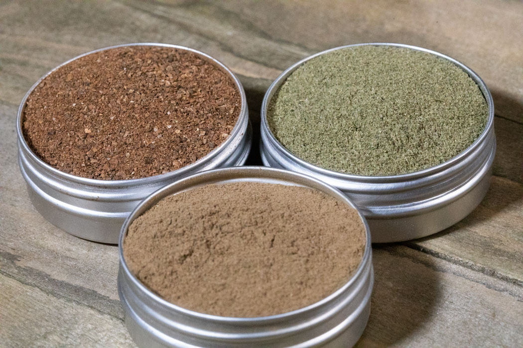 Three open tins of various powders