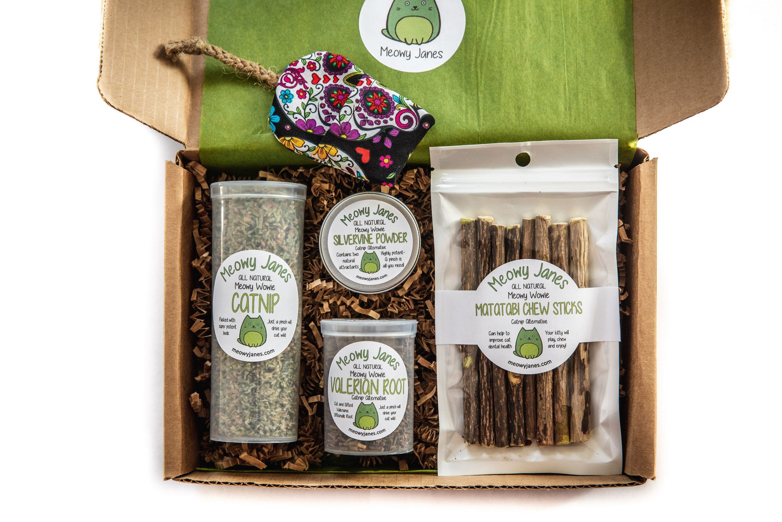 A box of catnip, silvervine powder, valerian root, matatabi chew sticks, and a cat toy