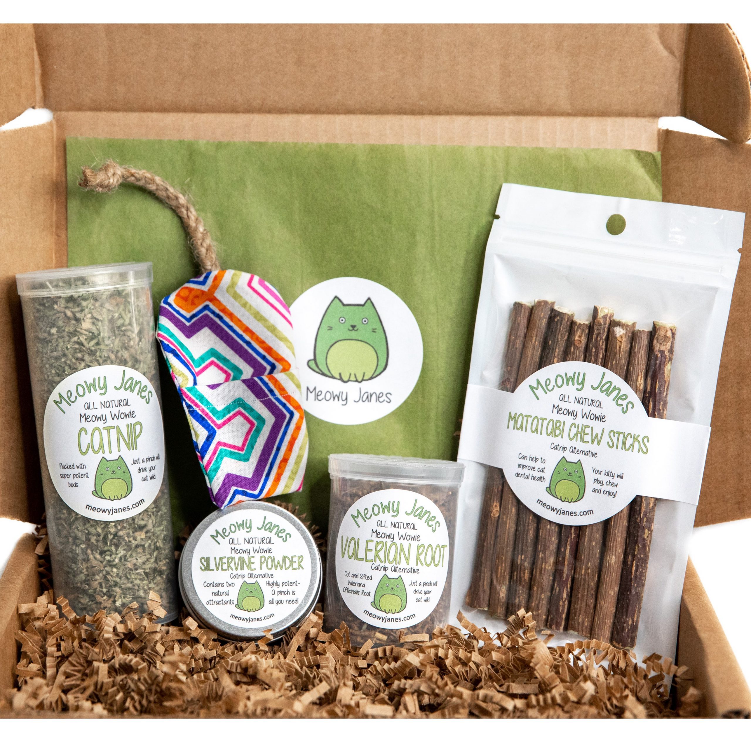 A box of catnip, silvervine powder, valerian root, matatabi chew sticks, and a cat toy