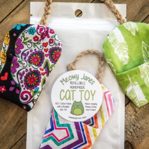 A fabric mouse toy in a bag with other fabric mouse toys around it.