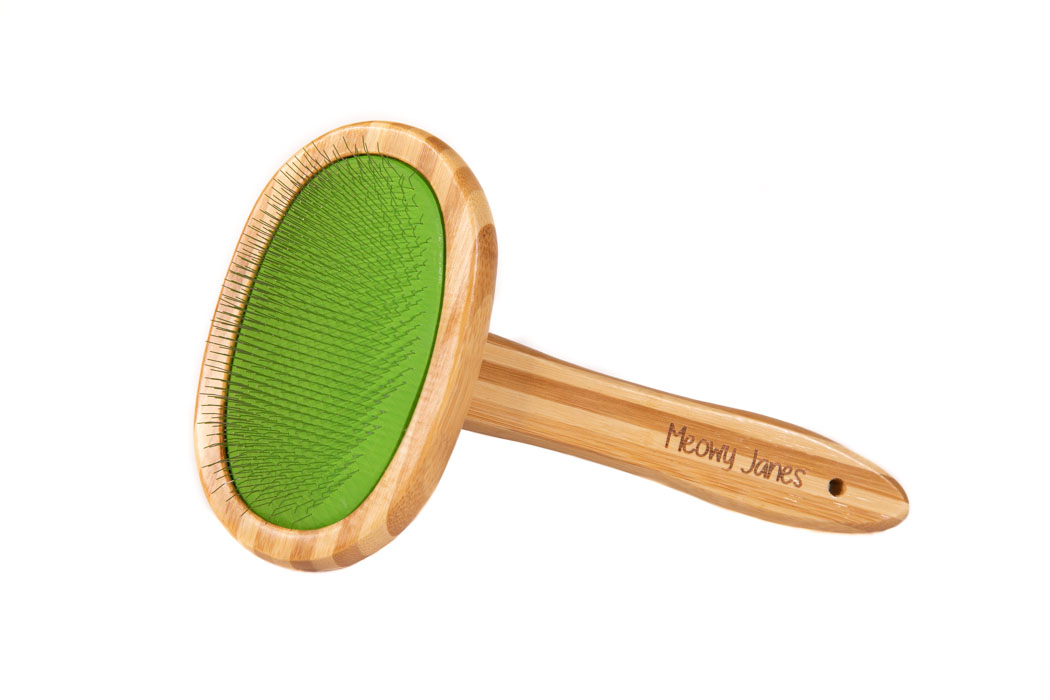 A green slicker brush with bamboo handle for cats