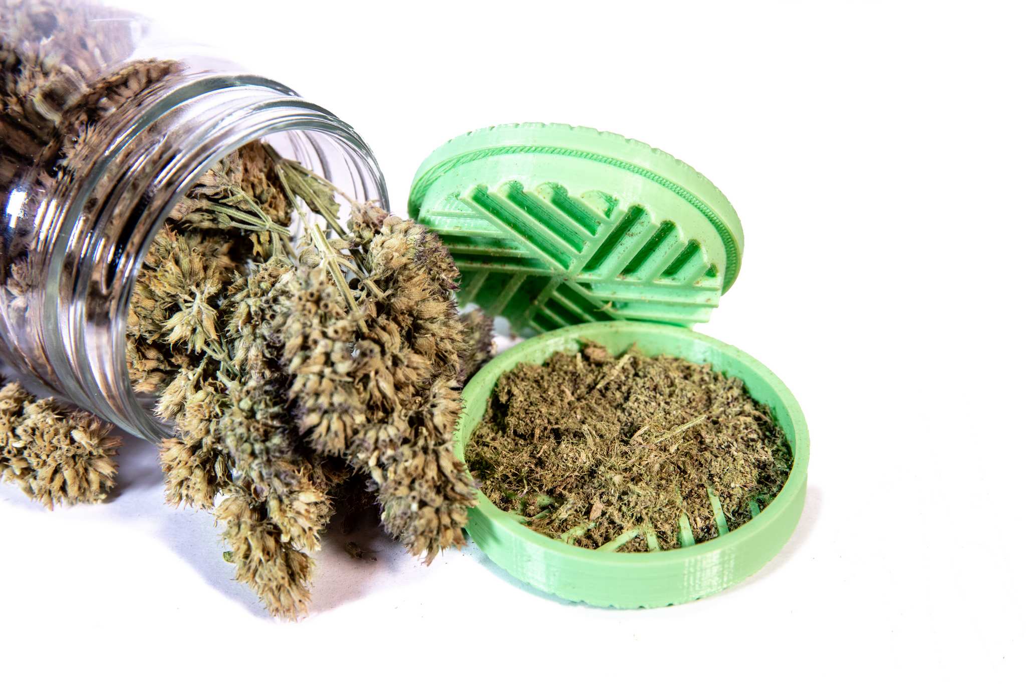 A jar of catnip buds and grinder
