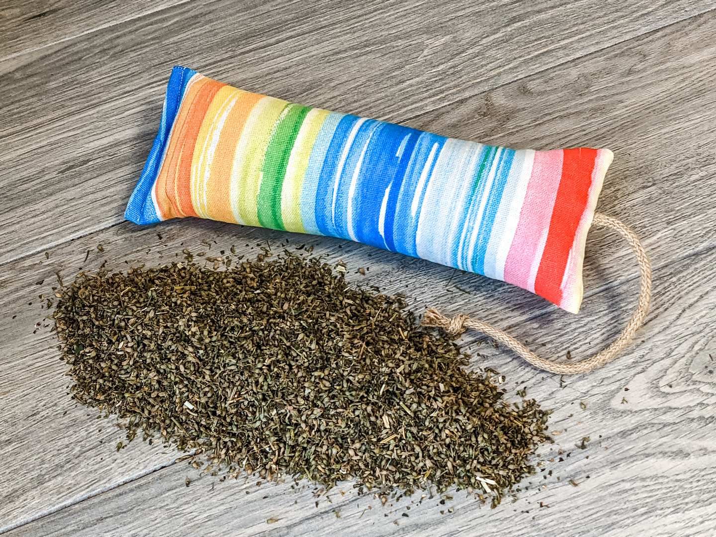A catnip kicker made from a multicolor watercolor rainbow themed fabric