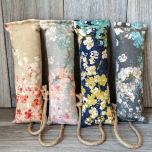 Multiple catnip kicker cat toys made out of a fabric with various prints that look like Japanese cherry blossoms