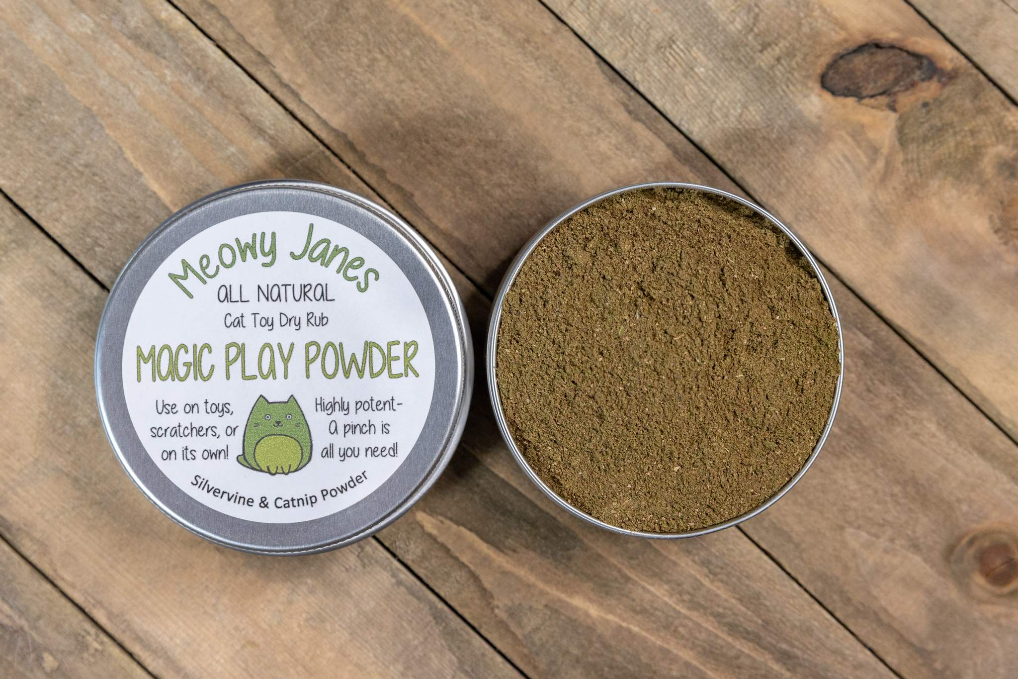 A open tin that says magic play powder filled with a brown powder