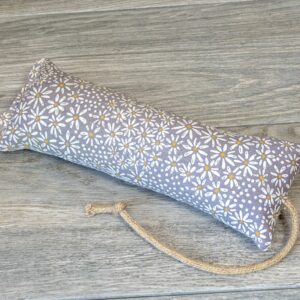 A catnip kicker made from a grey fabric with white daisy flowers