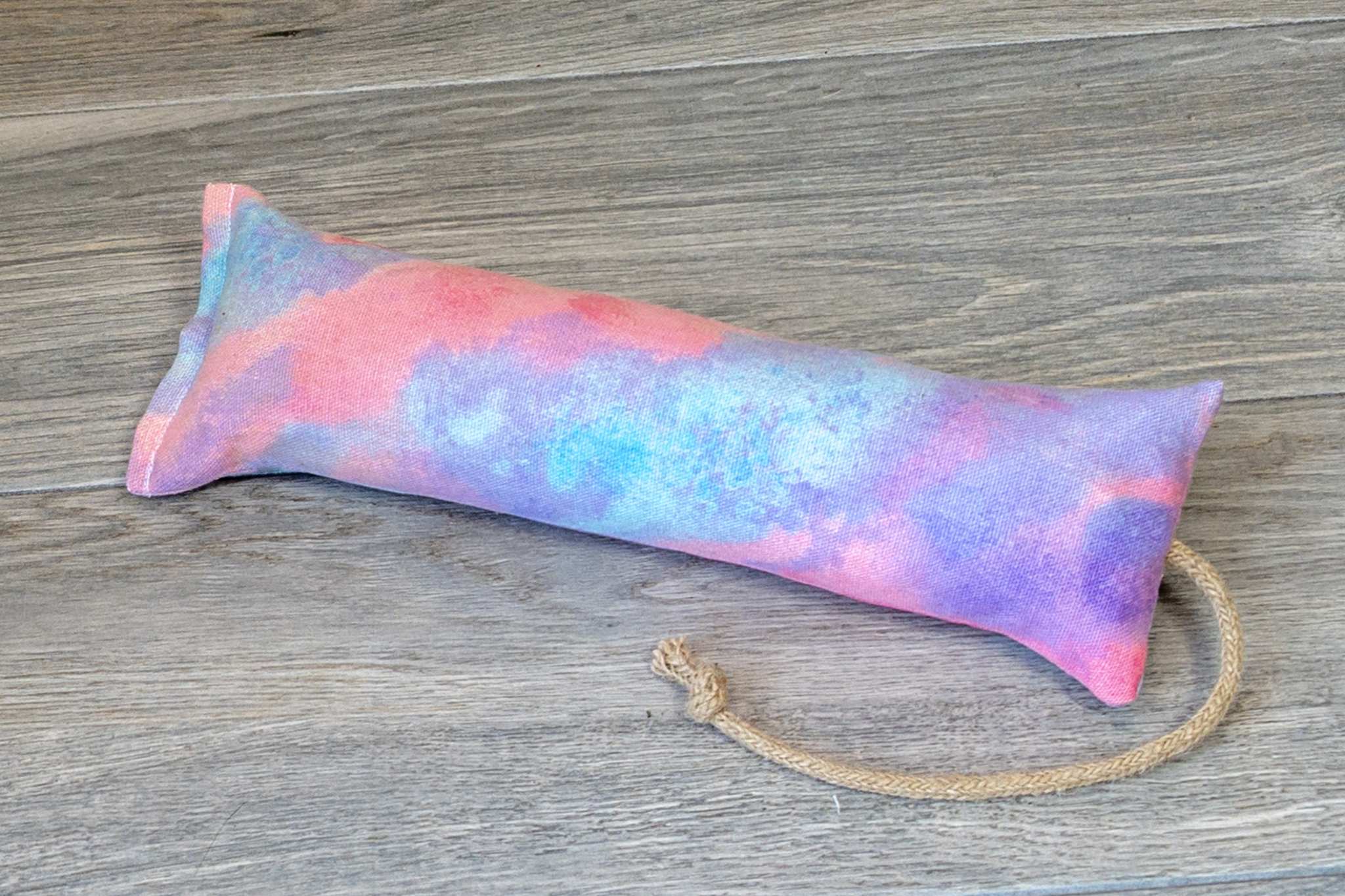 A catnip kicker made from a fabric that looks like multicolor pink, blue, and orange cotton candy