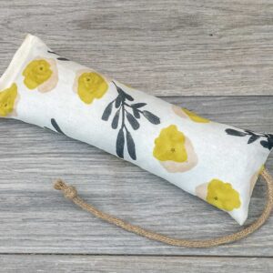 A catnip kicker made from a white fabric with yellow flower and green spring of foliage print