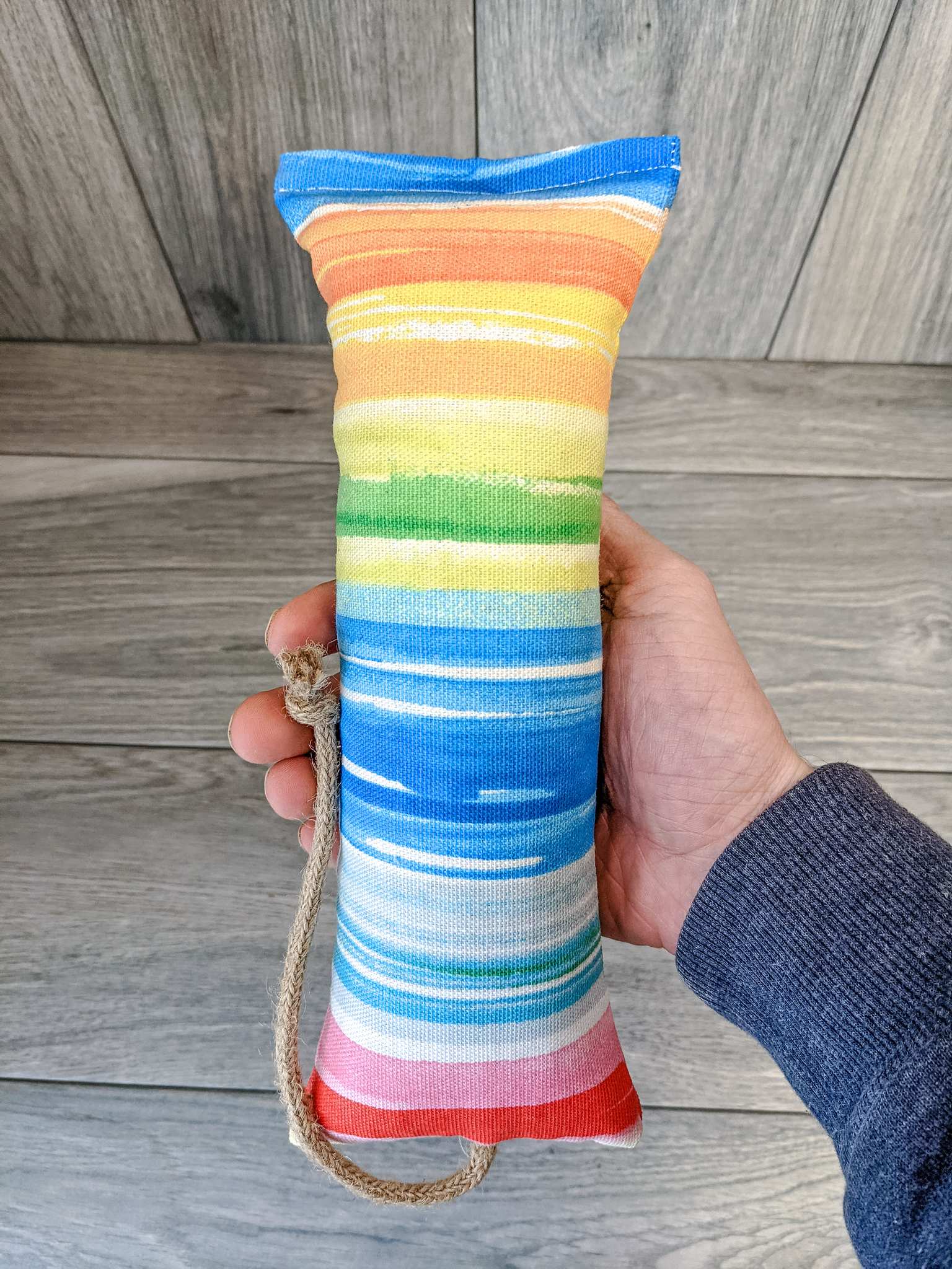 A catnip kicker made out of a fabric that looks like a watercolor rainbow stuffed with catnip