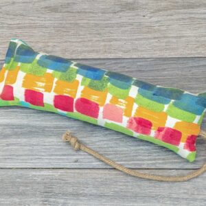 A catnip kicker made from a multicolor fabric with square swatches on it.