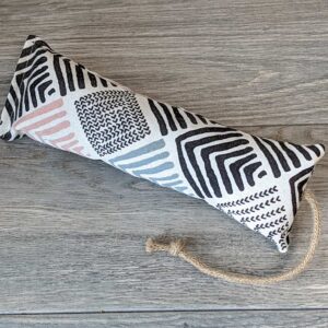 A catnip kicker made from a white fabric with black and grey modern looking stripes on it. 