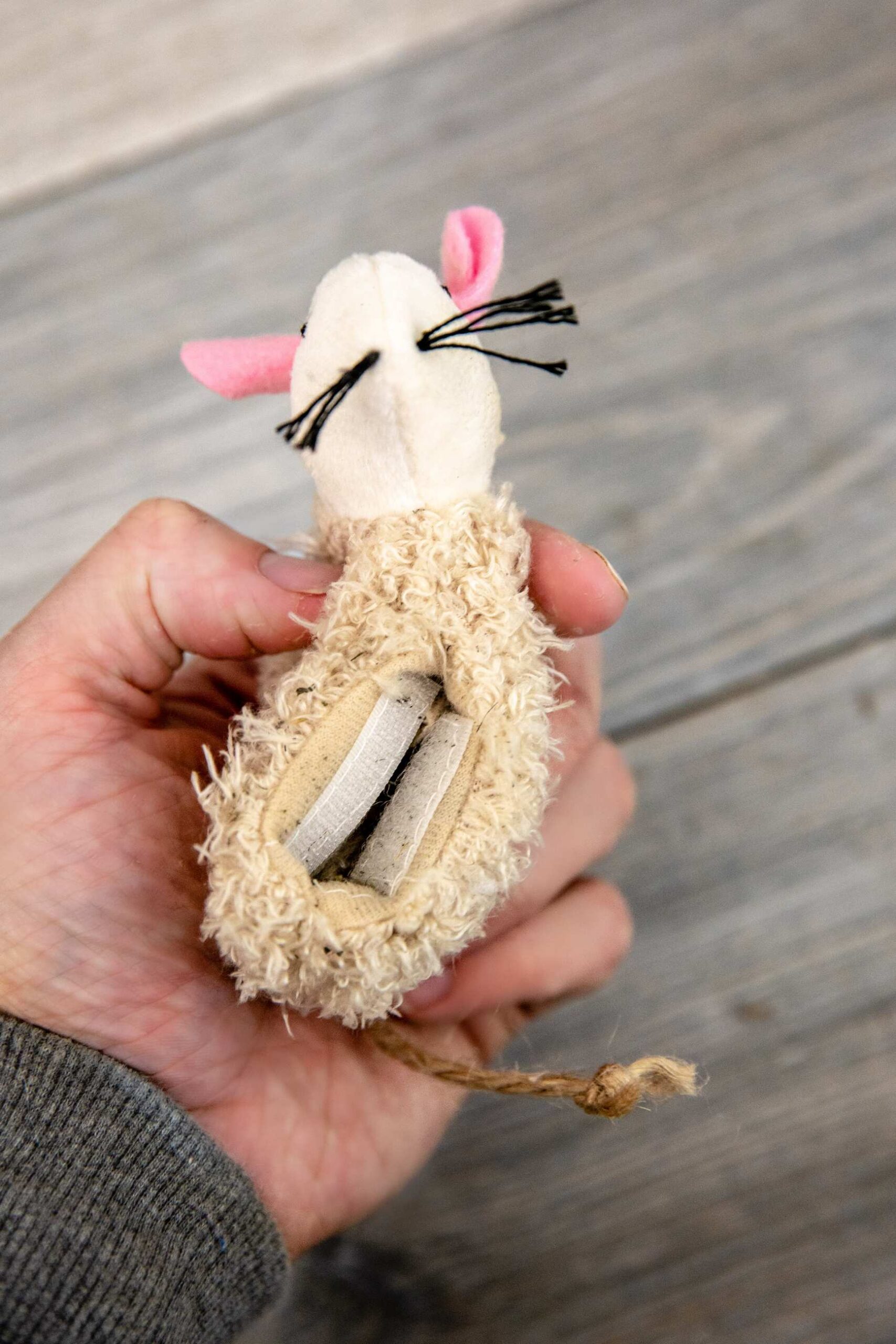 A hand holding a mouse toy made of fabric