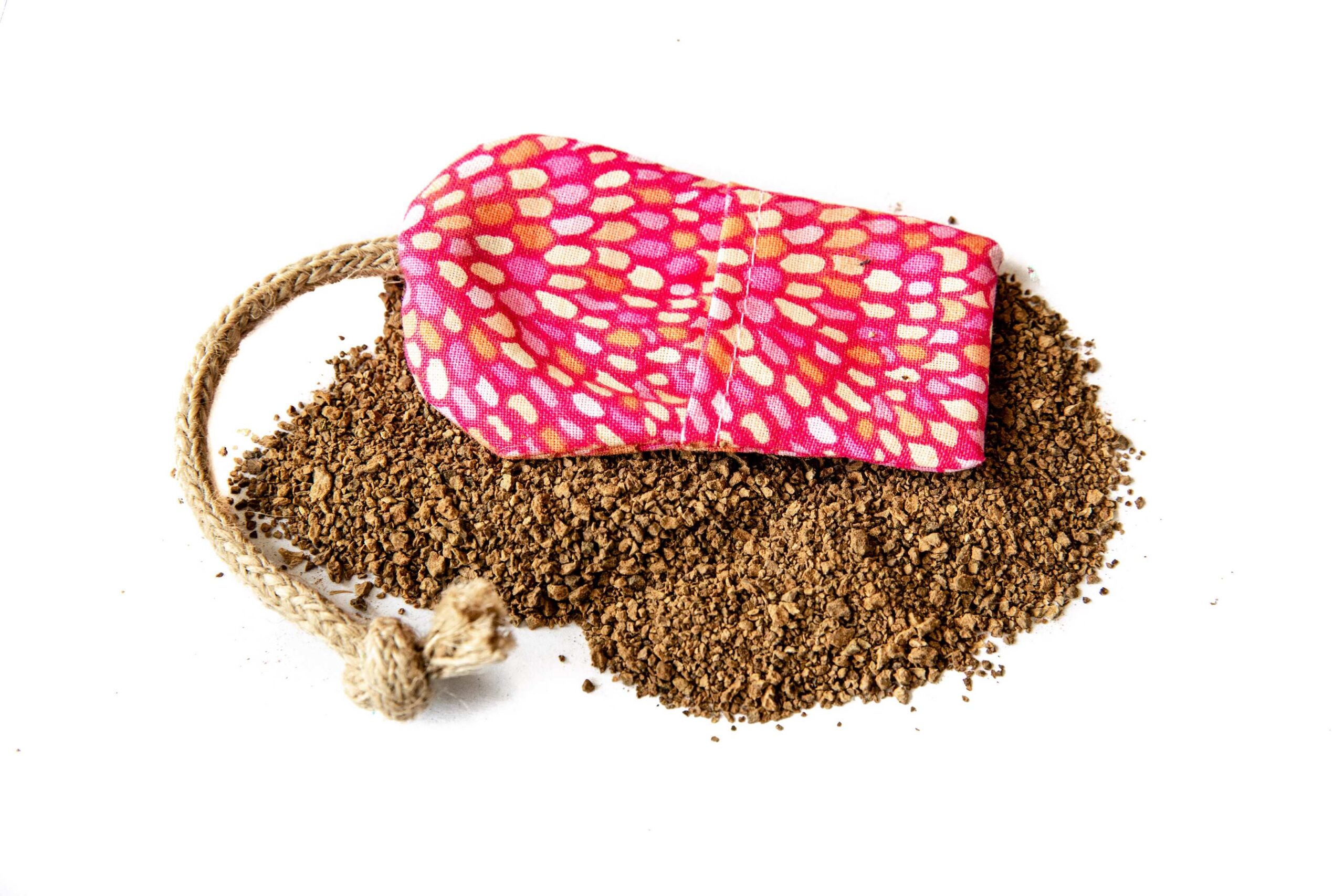 A fabric mouse toy on top of a pile of catnip