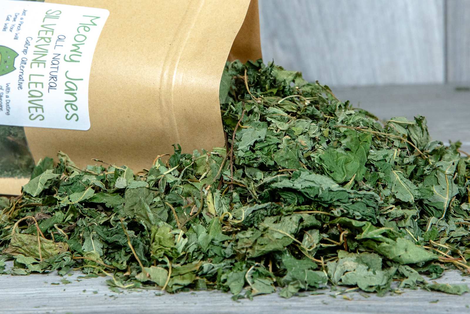 aA bag of silvervine leaves with a pile of silvervine leaves pouring out of it