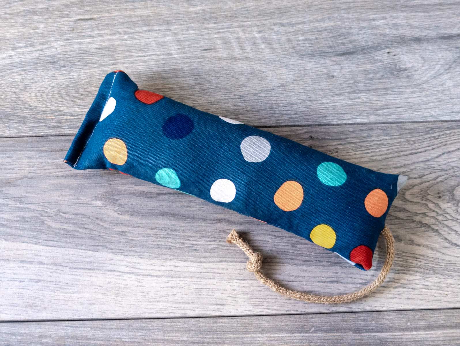 A catnip kicker cat toy made out of a fabric with a polka dot print