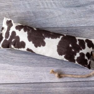 A catnip kicker cat toy made out of a fabric black and white cow print