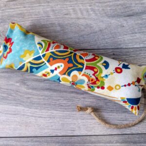 A catnip kicker cat toy made out of a fabric with a multi color maximalist print