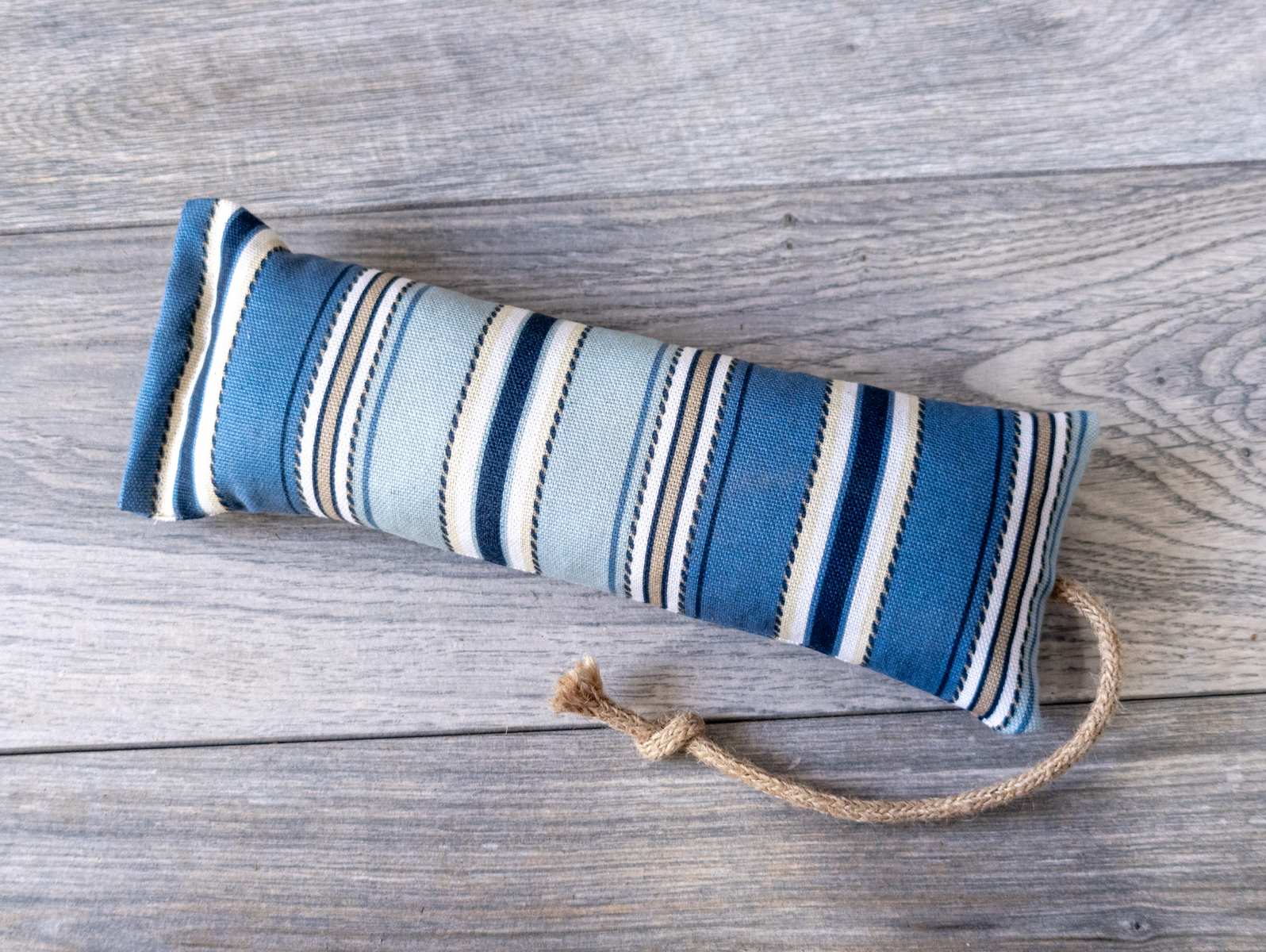 A catnip kicker cat toy made out of a fabric with a blue nautical stripe print