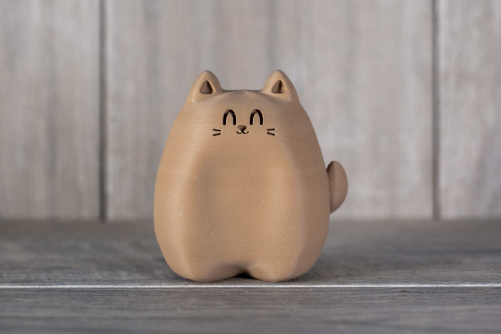 A small figure of a cat that looks like wood