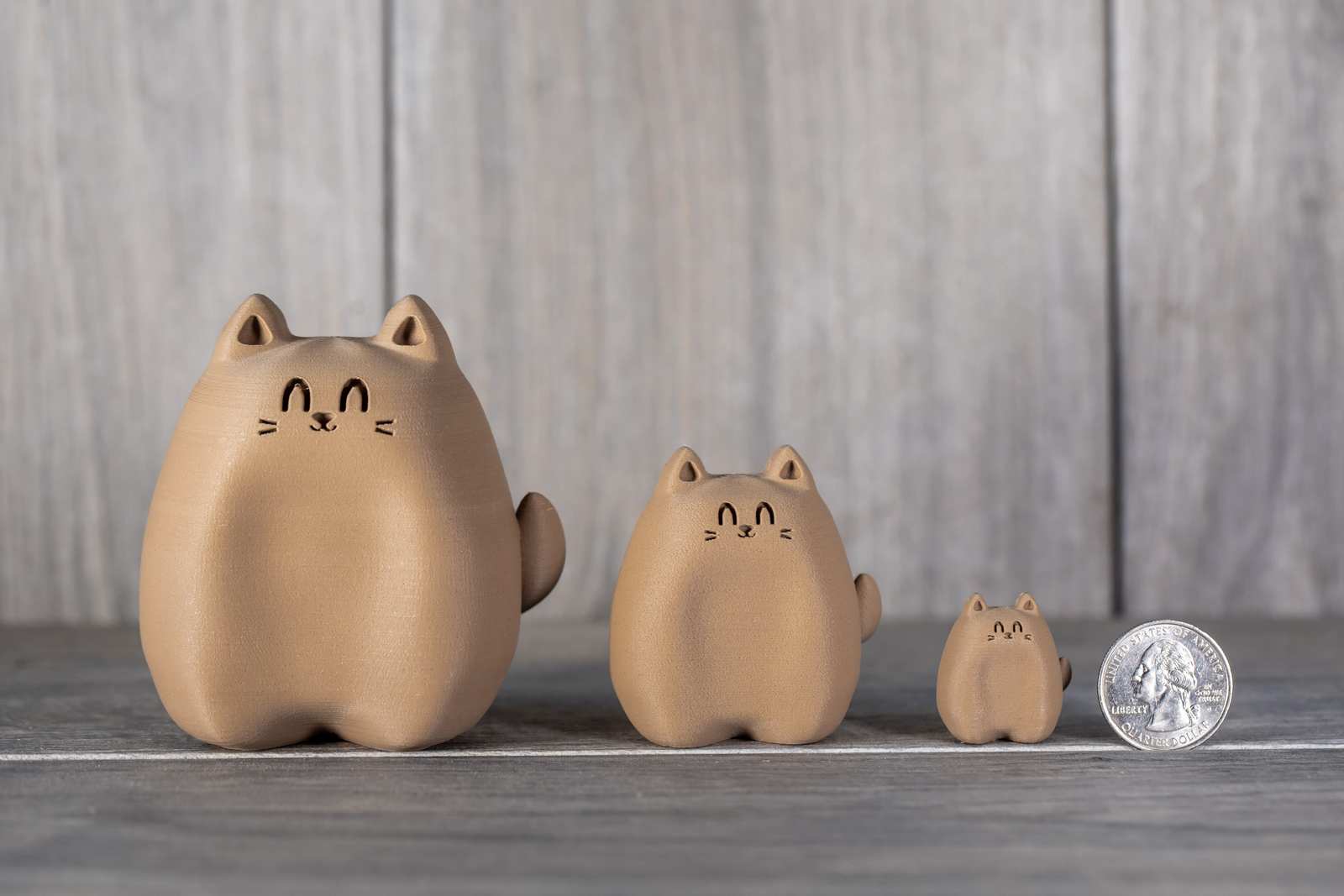 Various sizes of figures of 3D printed cats that looks like wood