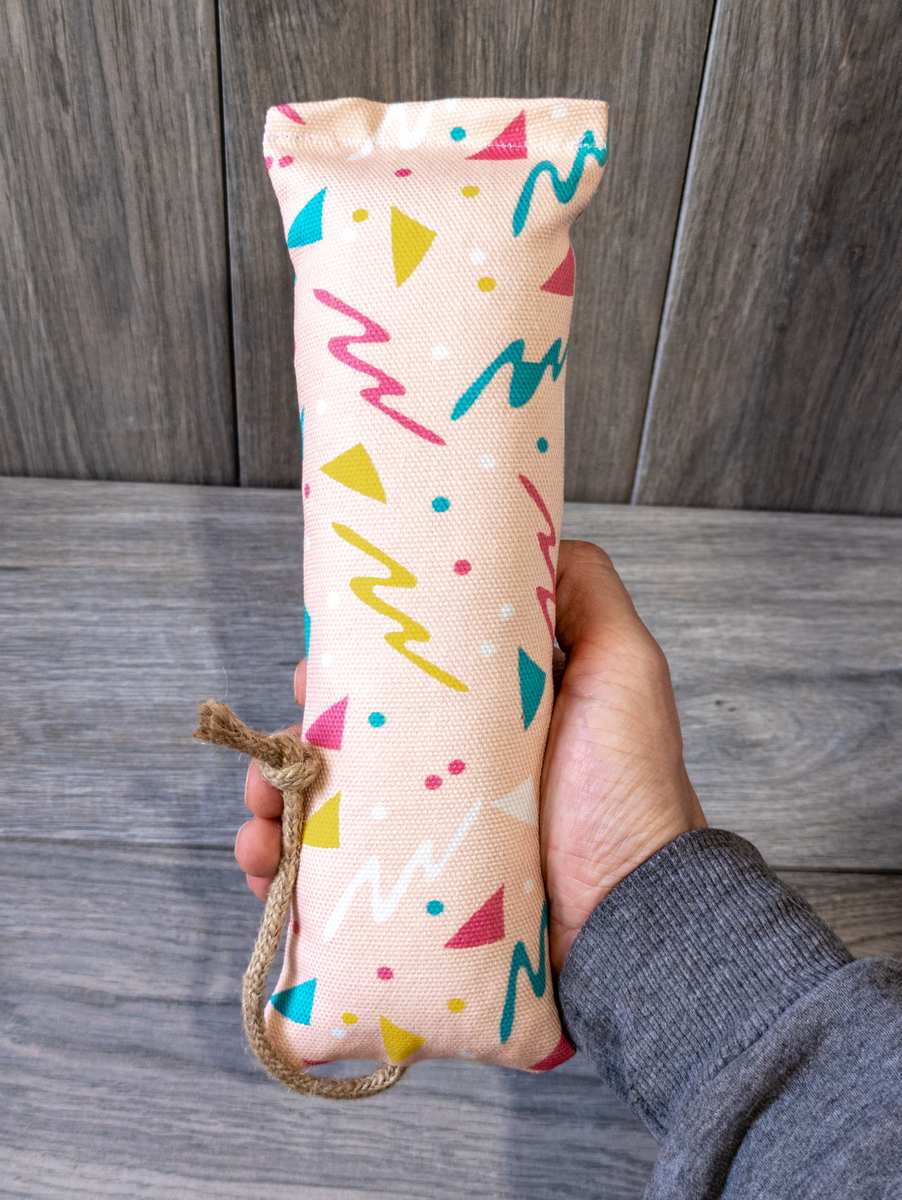 A catnip kicker made out a fabric with a pink 90s themed print