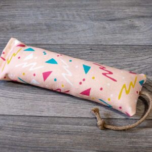 A catnip kicker made out a fabric with a pink 90s themed print