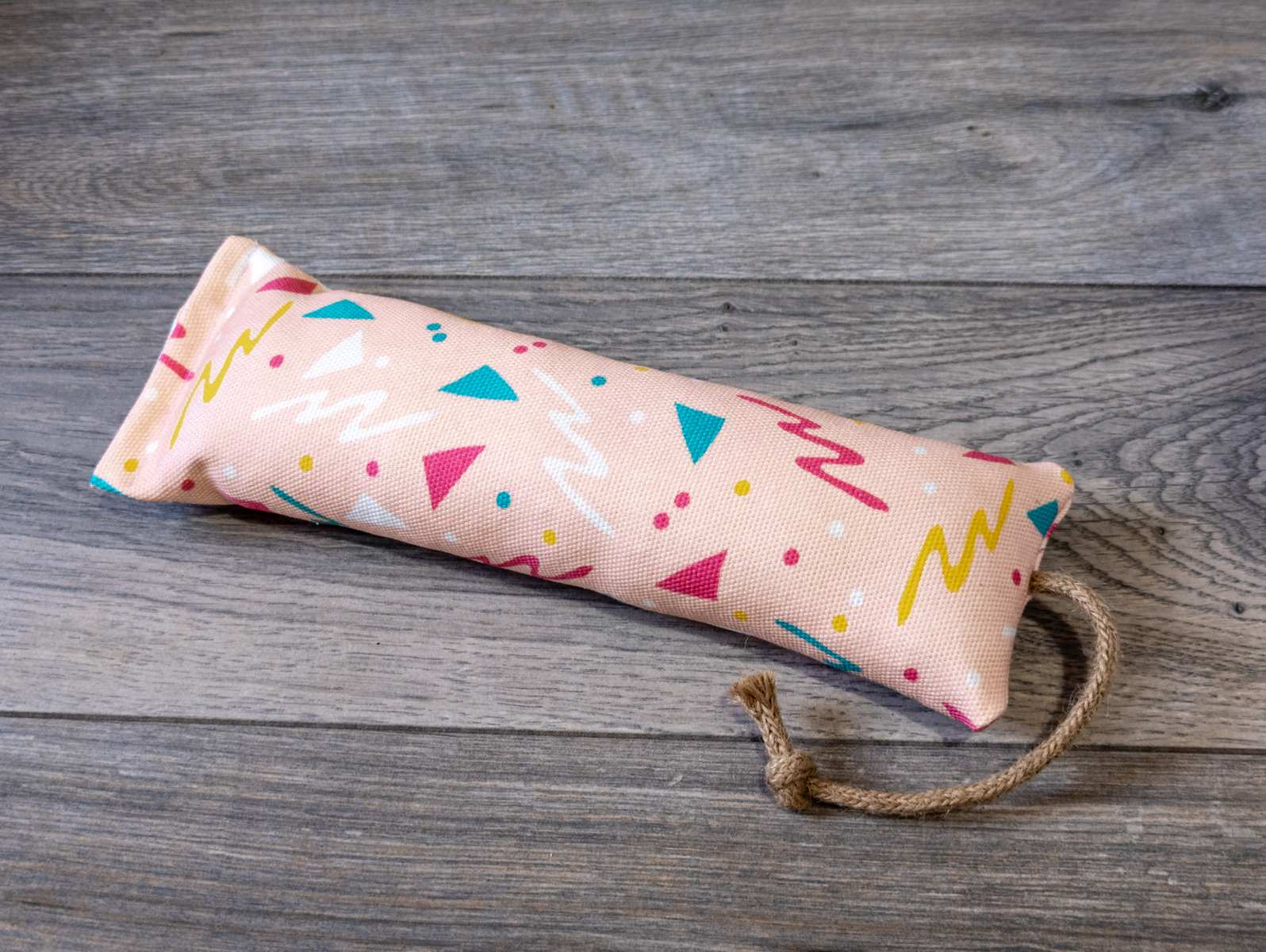 A catnip kicker made out a fabric with a pink 90s themed print