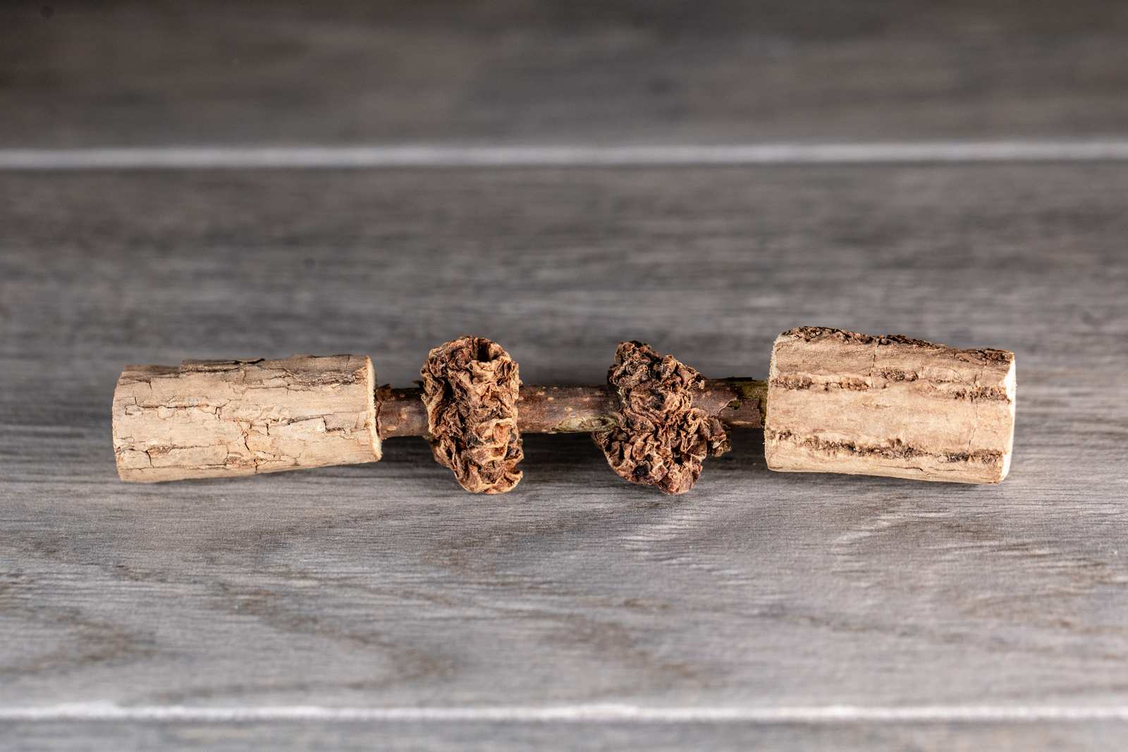 Matatabi sticks with gall fruit threaded onto the stick and larger diameter sticks as the end caps