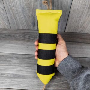 A catnip filled kicker made of a black and yellow fabric that looks like a bumble bee