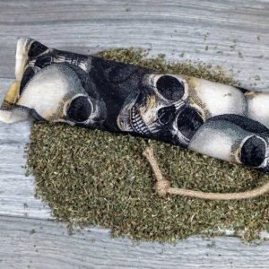 A catnip kicker made of a black fabric with skulls on it