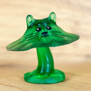A green translucent cat mushroom figurine made of resin with painted face