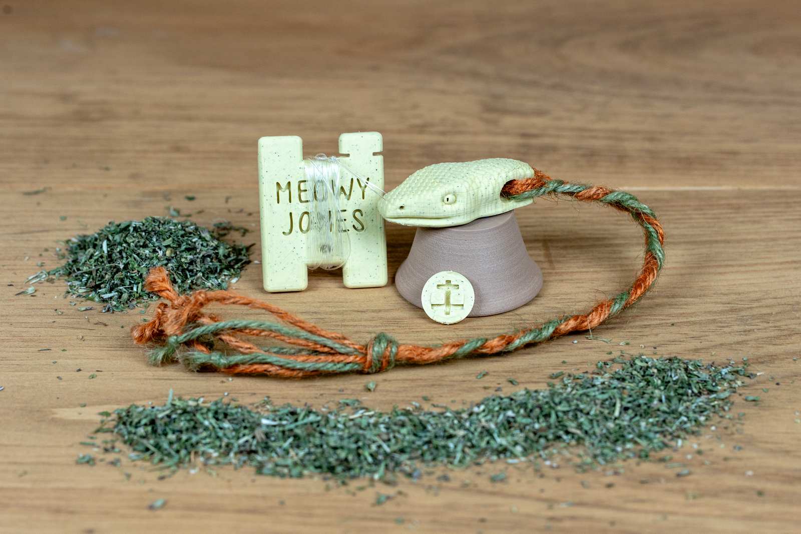 A 3D printed Snake toy for cats with various accessories and pile of catnip