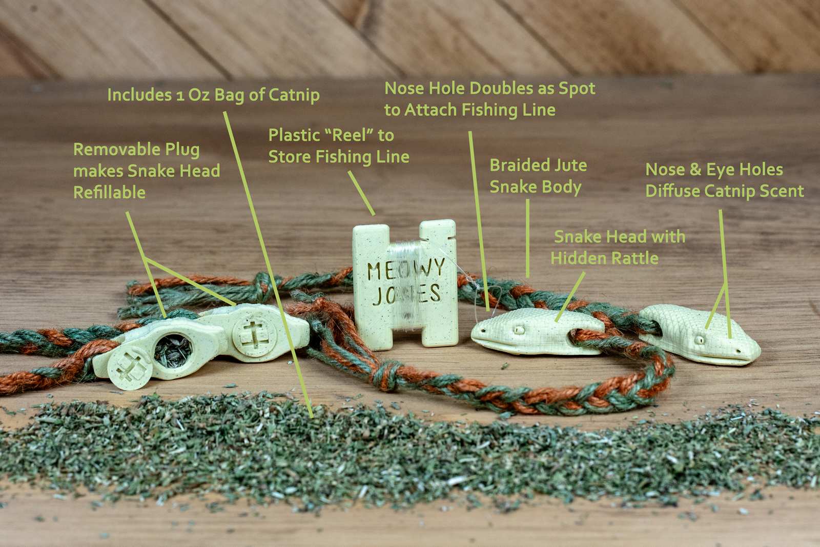 A 3D printed Snake toy for cats with various accessories and pile of catnip and labels for features of the toy
