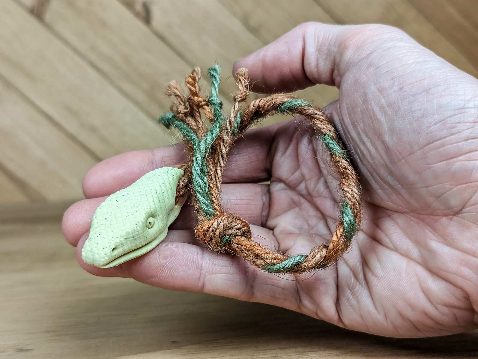 A 3D printed Snake toy for cats held in a hand