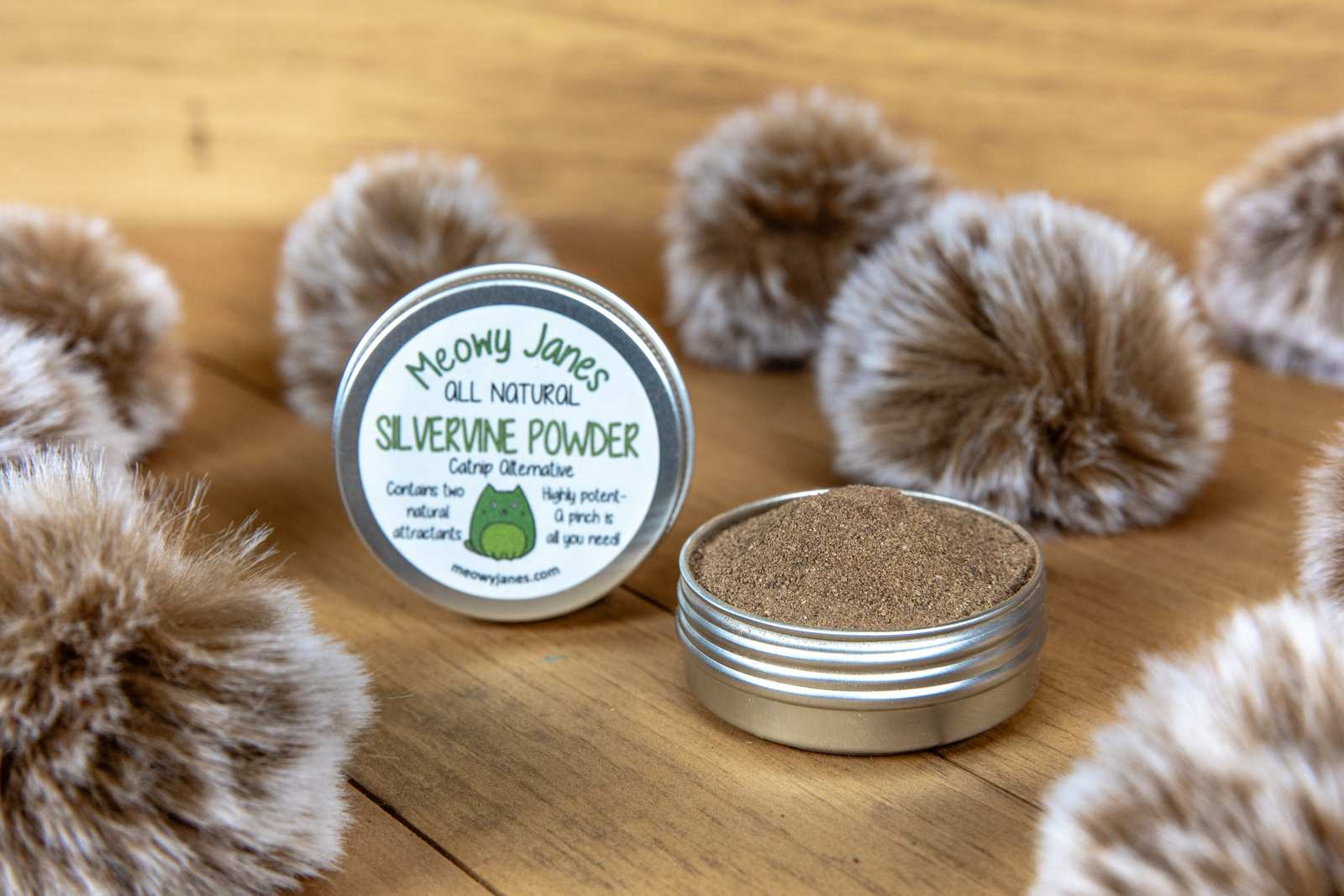 A tin of silvervine powder with fuzzy pom pom toys