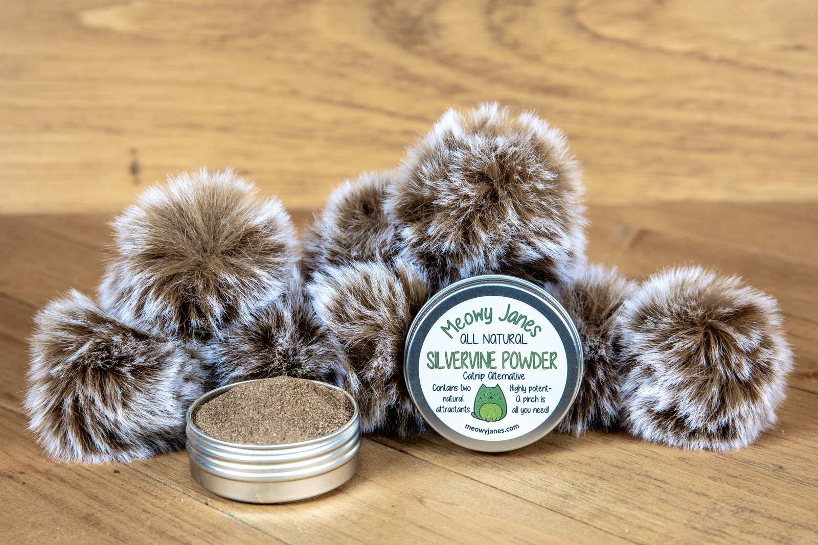 A tin of silvervine powder with fuzzy pom pom toys