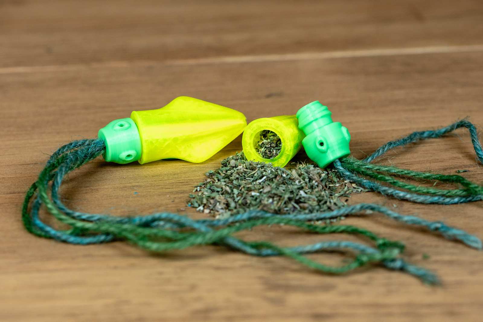 A cat toy that looks like a small squid with yellow body, green head, and jute tentacles. Head is removed from the body to show the catnip inside