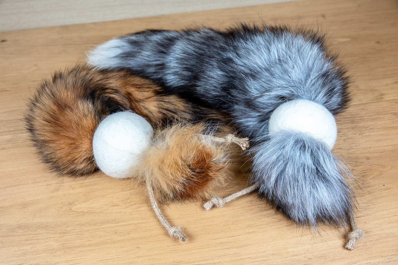 Cat toys made out of a fox tail attached to a wool ball