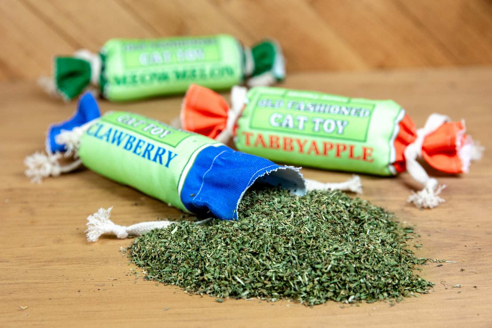 Catnip spilling out of a canvas cat toy that looks like a penny candy roll.