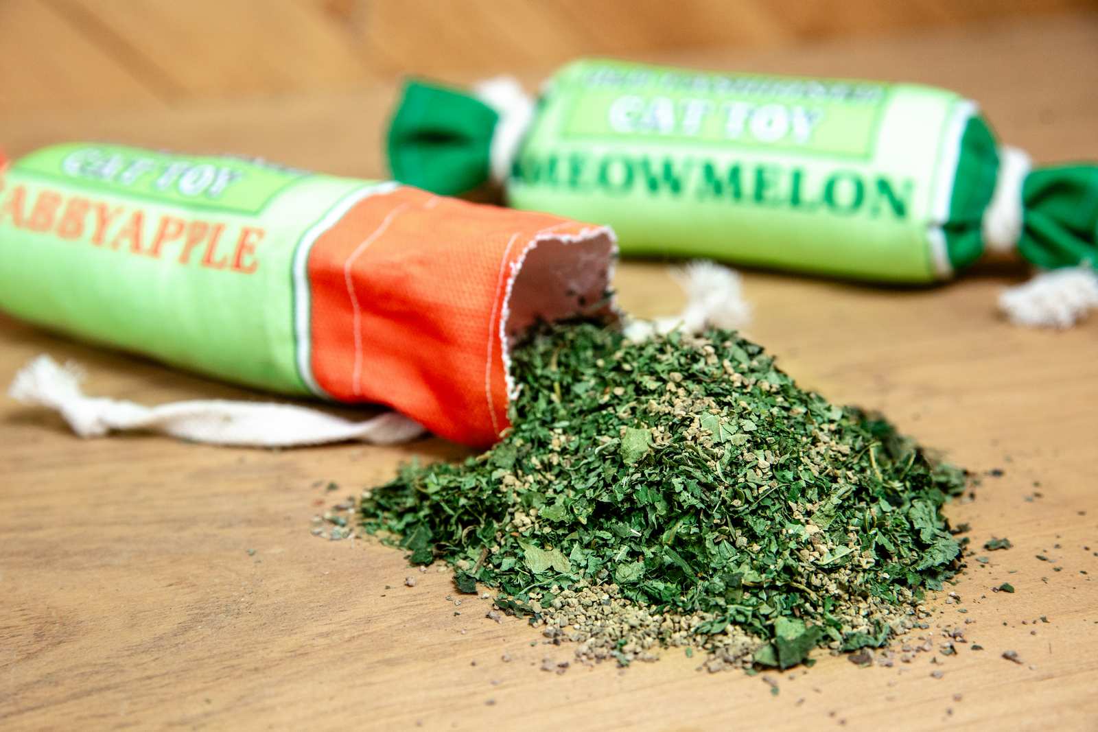 Catnip spilling out of a canvas cat toy that looks like a penny candy roll.