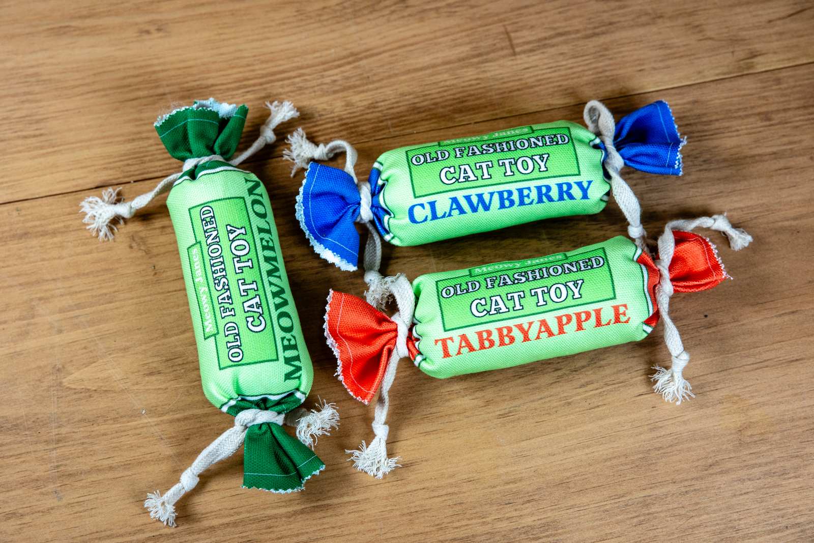 Three penny candy cat toys in different colors; blue, red and green