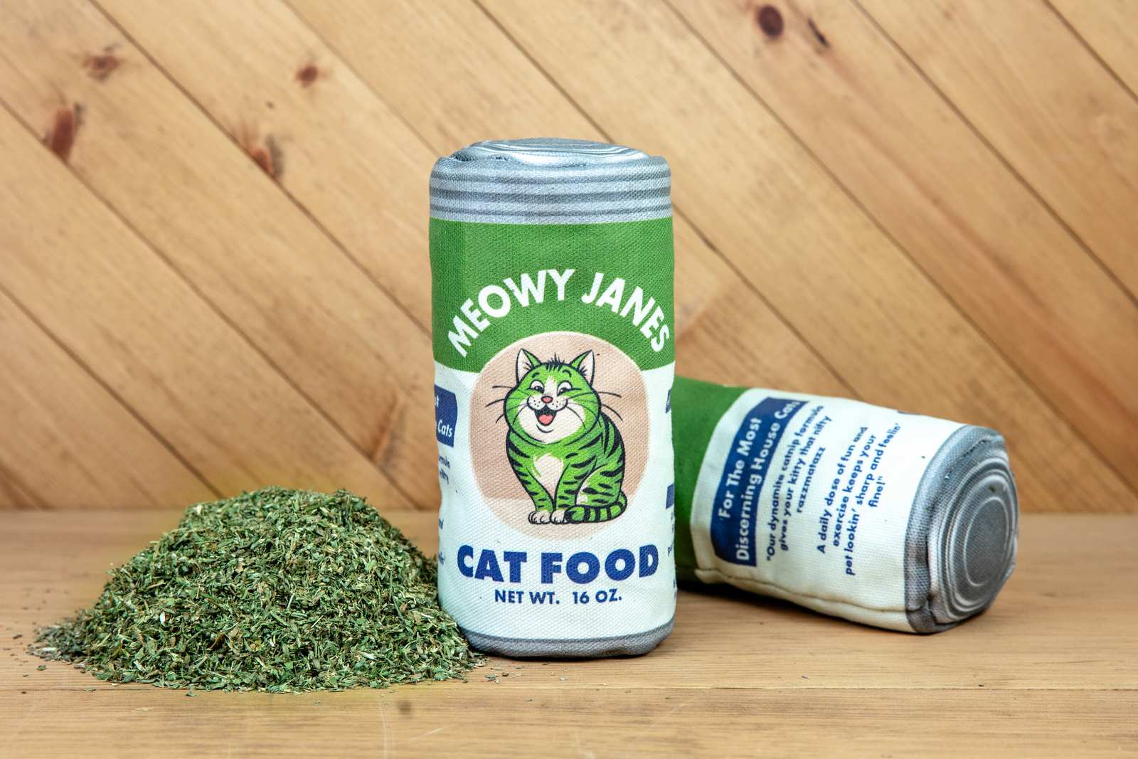 A sewn toy that looks like a can of cat food next to a pile of catnip