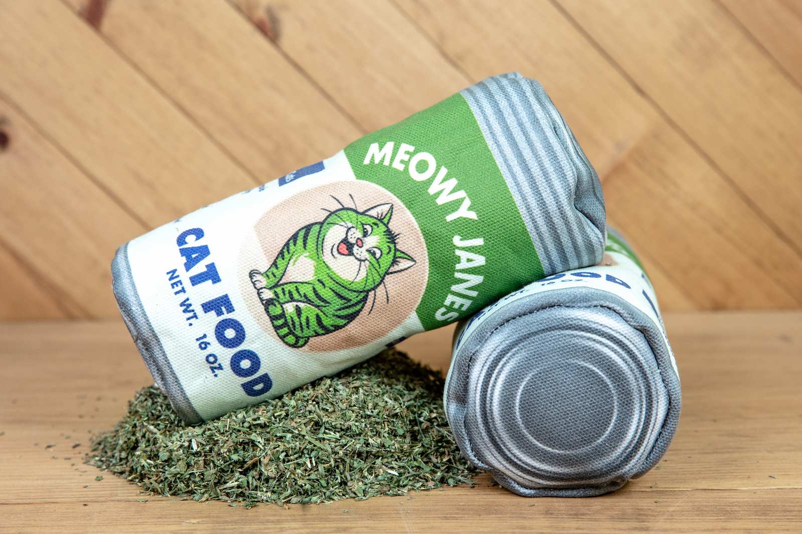 A sewn toy that looks like a can of cat food next to a pile of catnip